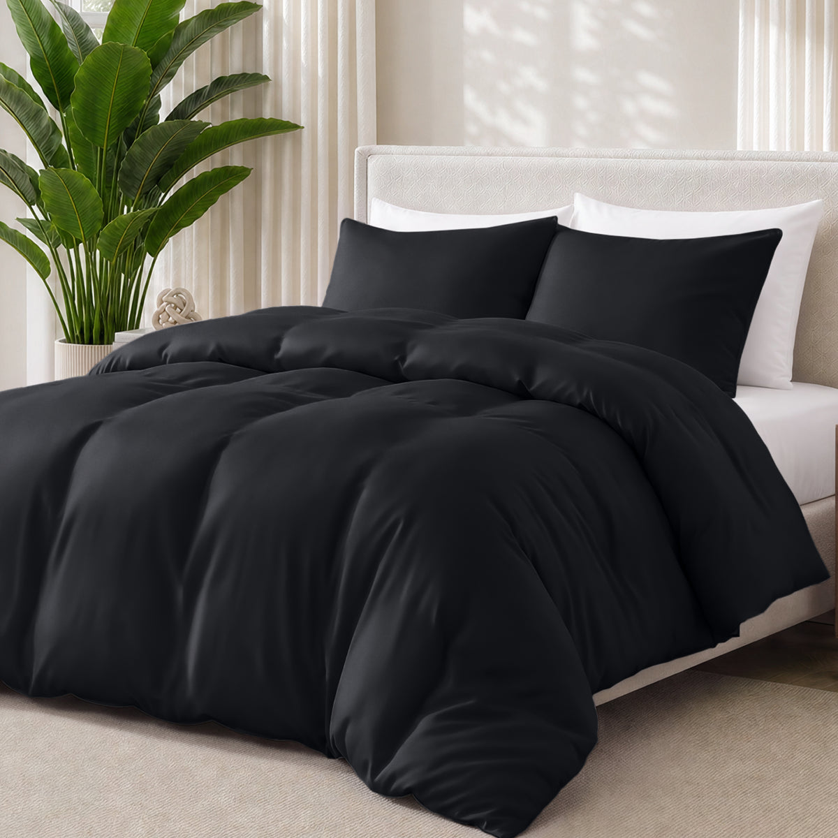 Black bedding set on a bed with a plant in the background