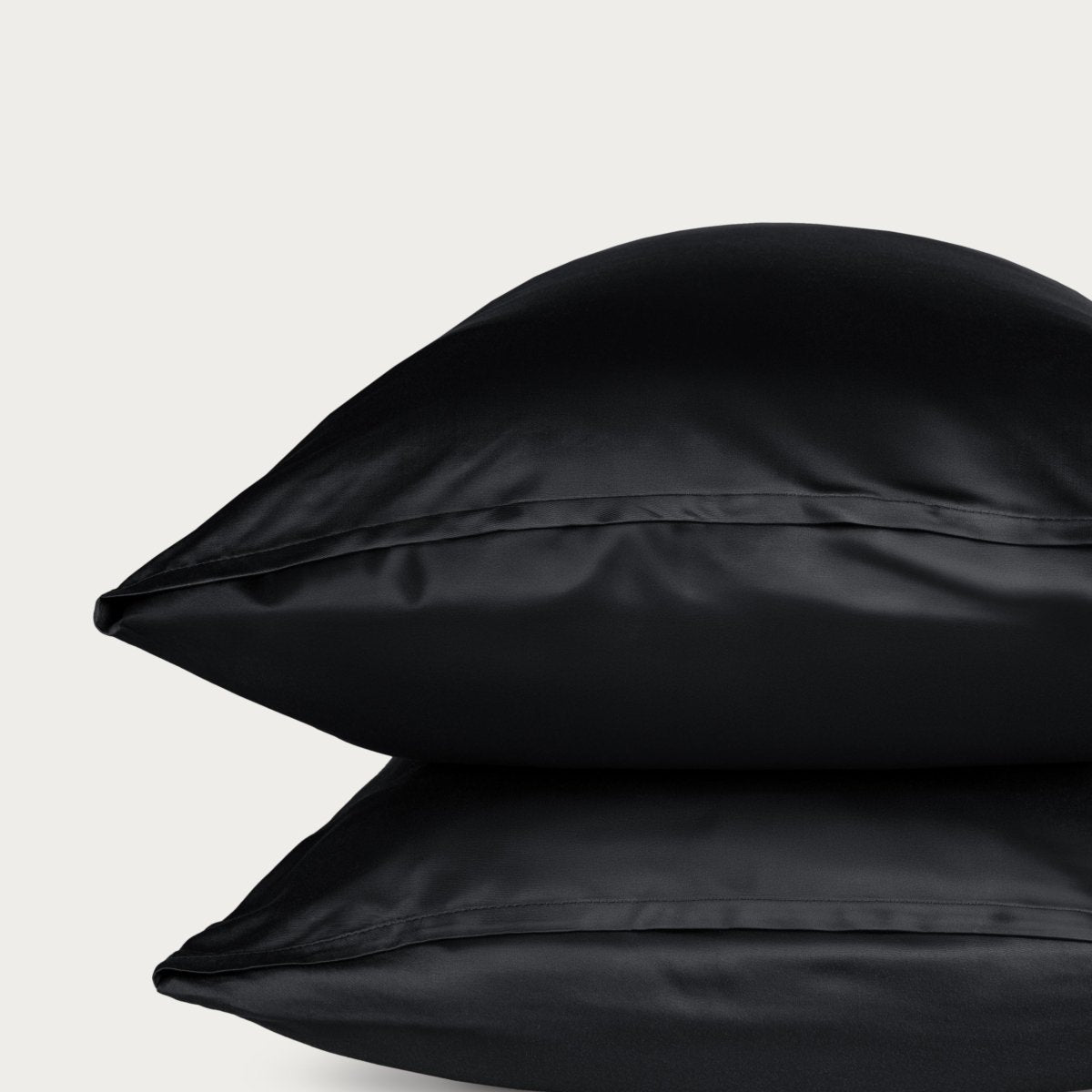 Bamboo pillowcase and bedding against a woven headboard with a plant in the corner.