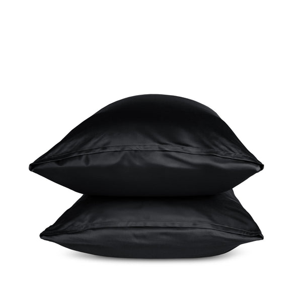 Two black pillows stacked on a white background
