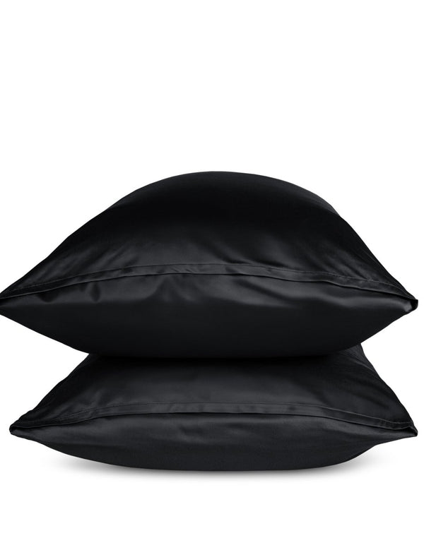 Two black pillows stacked on a white background