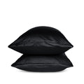 Two black pillows stacked on a white background