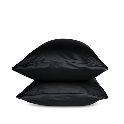Two black pillows stacked on a white background
