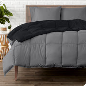 A wooden bed frame with a reversible comforter and sheet set on the mattress