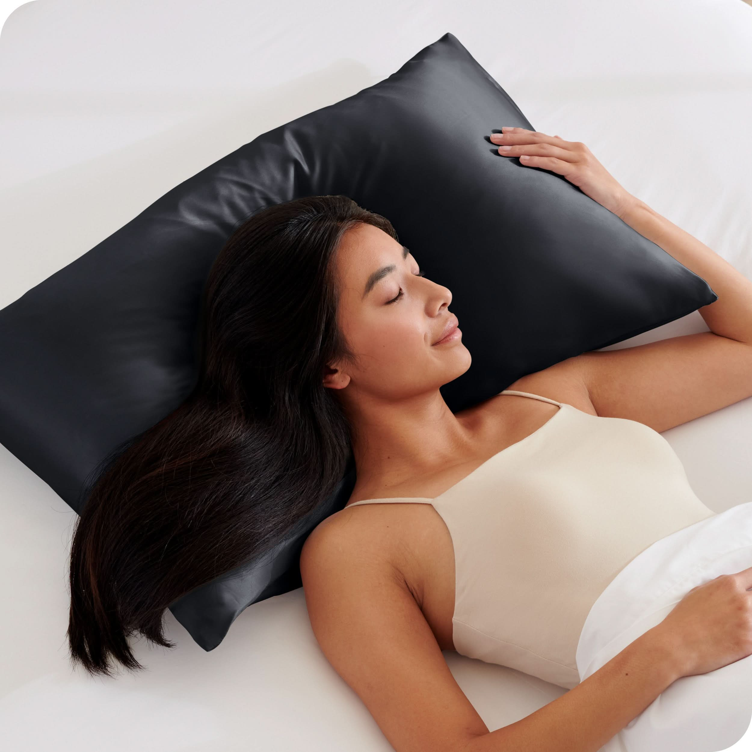 A woman is sleeping with her head on a silk pillowcase