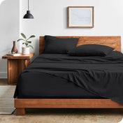 Modern bedroom with washed sheets draped over the end and the side of the bed