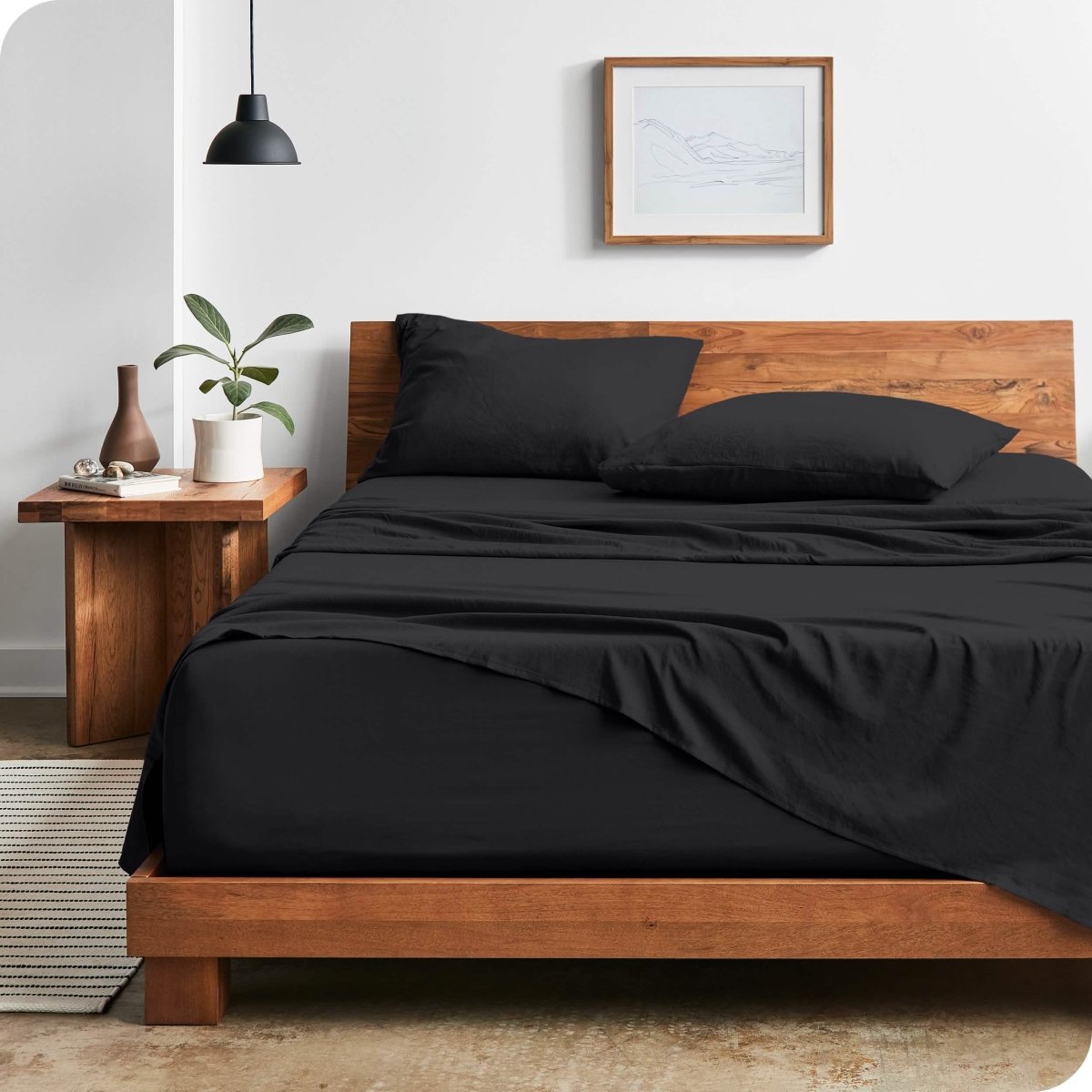 Modern bedroom with washed sheets draped over the end and the side of the bed