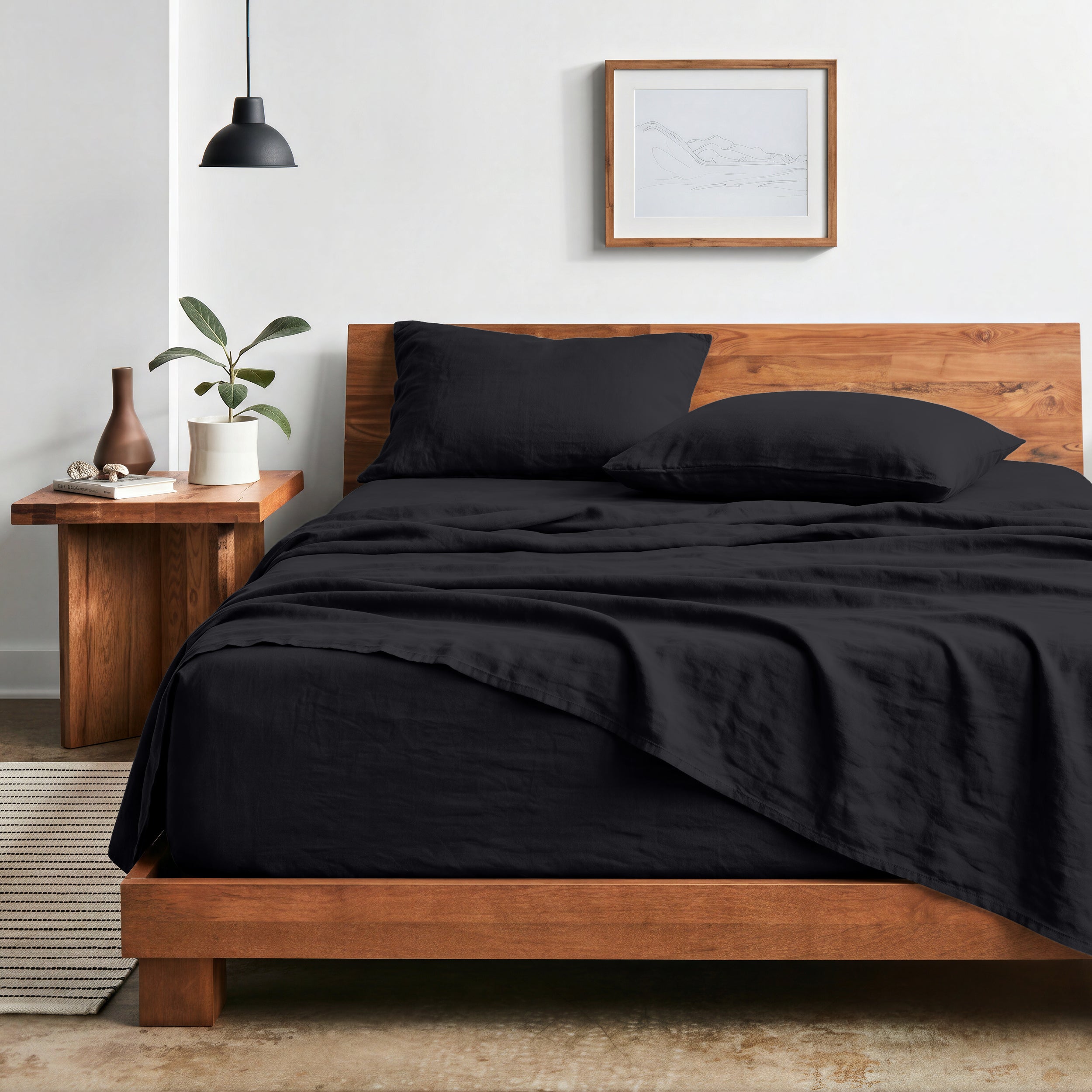 Bedroom with sheet set on a wooden bed frame and side table