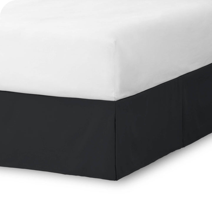 The corner of a bed skirt on a bed frame
