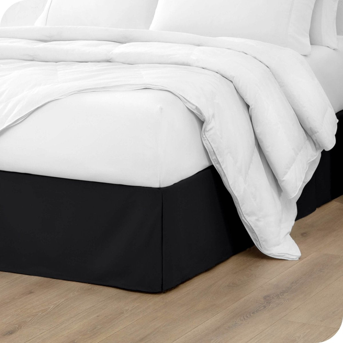 A modern bed with a microfiber bed skirt with pleats on the corners and midway on each side