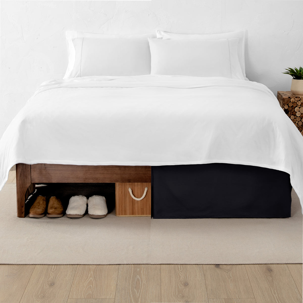 One side of a bed has shoes and a box under it while the other side has a bed skirt so that under the bed is hidden from view