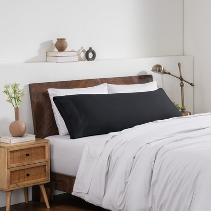 Bedroom with a wooden headboard and white bedding, featuring a nightstand and decorative items.