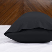 Body pillowcase with an envelope closure on a bed with a wooden headboard
