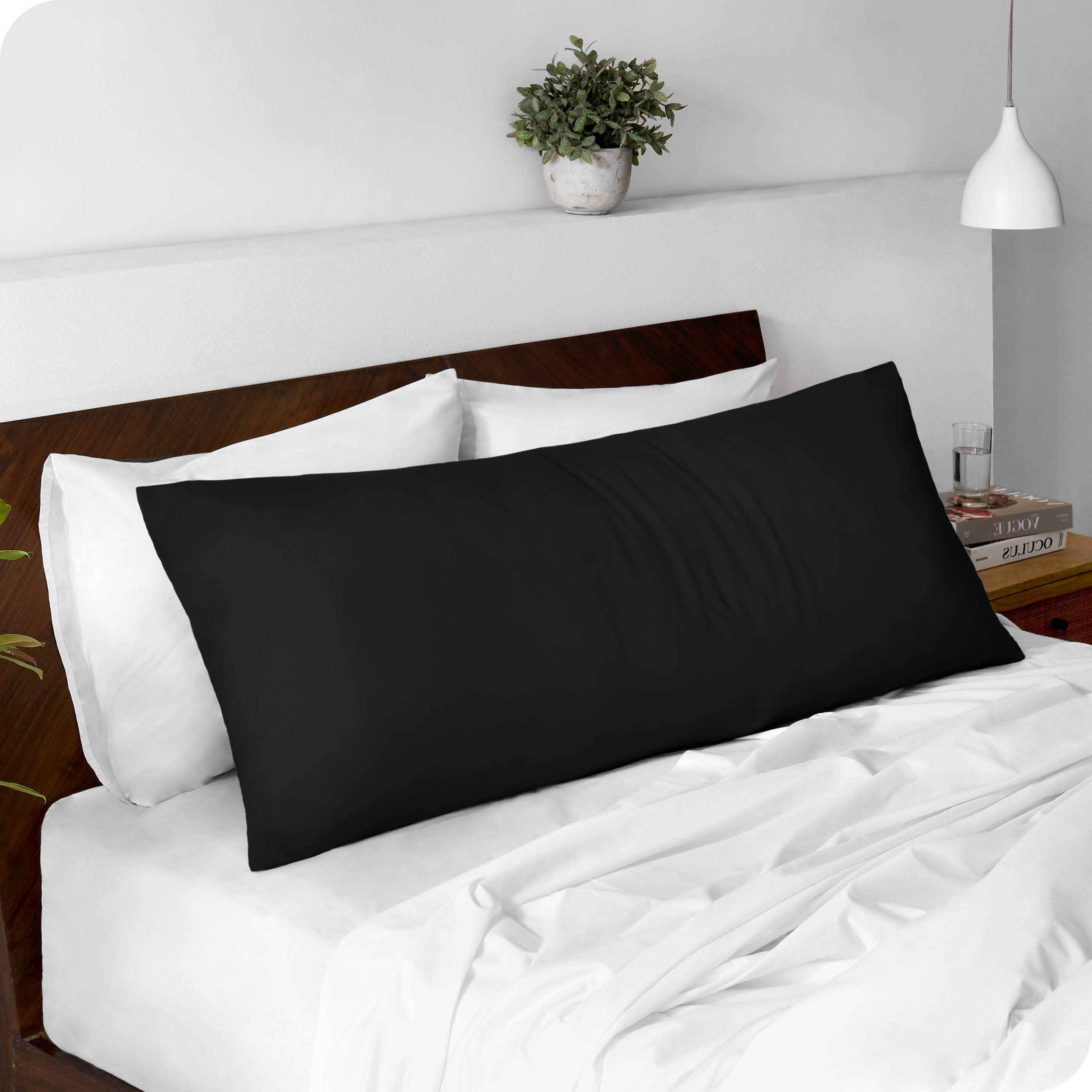 A body pillowcase on a pillow set against a headboard