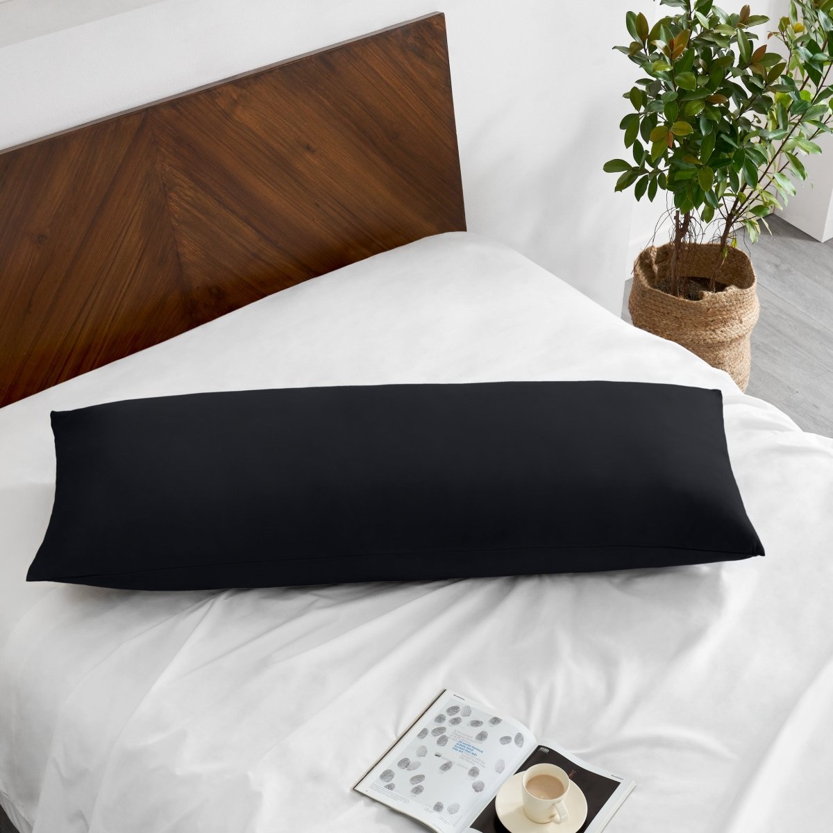 Pillowcase on a body pillow with a wooden headboard and plant in the background