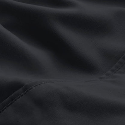 A close-up of microfiber fabric with soft folds and a visible stitched seam.