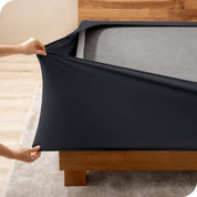 A person stretching a box spring cover