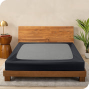A cover on a box spring set on a wooden bed frame