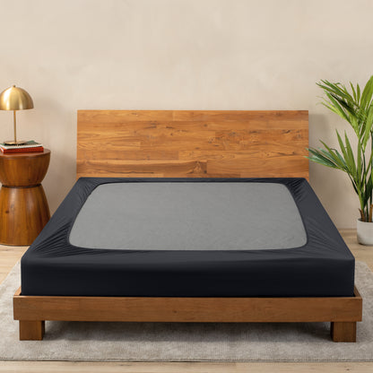A cover on a box spring set on a wooden bed frame