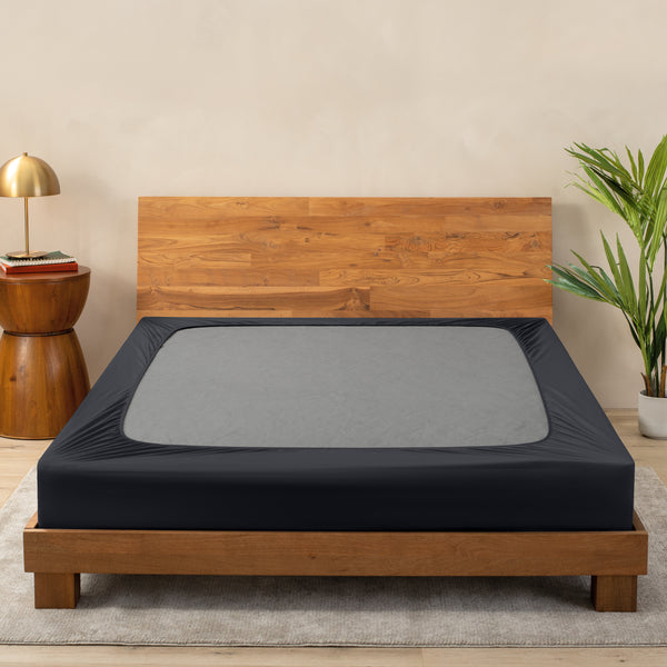 A cover on a box spring set on a wooden bed frame