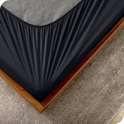 The corner of a box spring with a cover on it