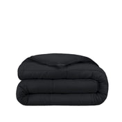 Folded black comforter on a white background