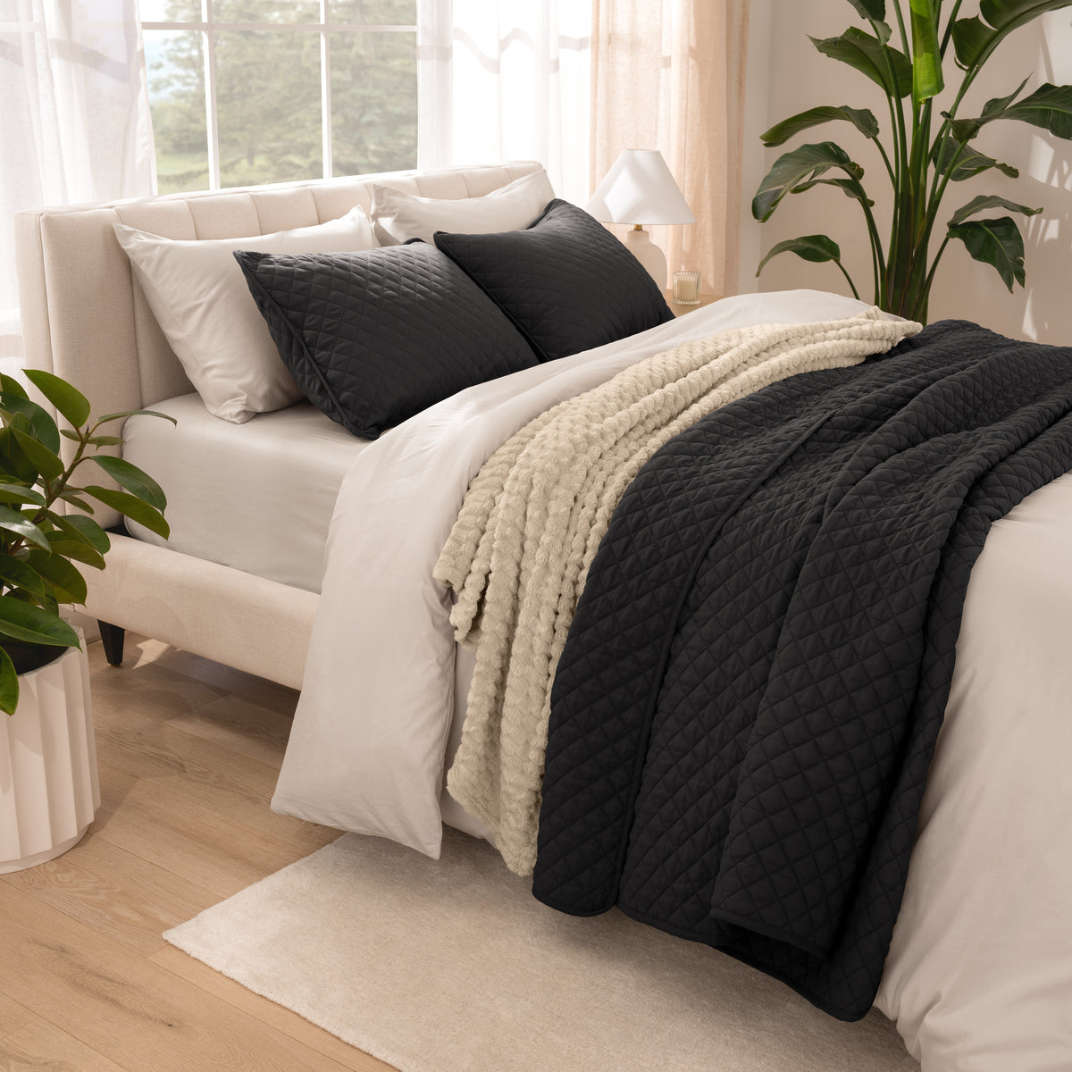 Side view of bed with coverlet set draped on a bed made with a duvet set