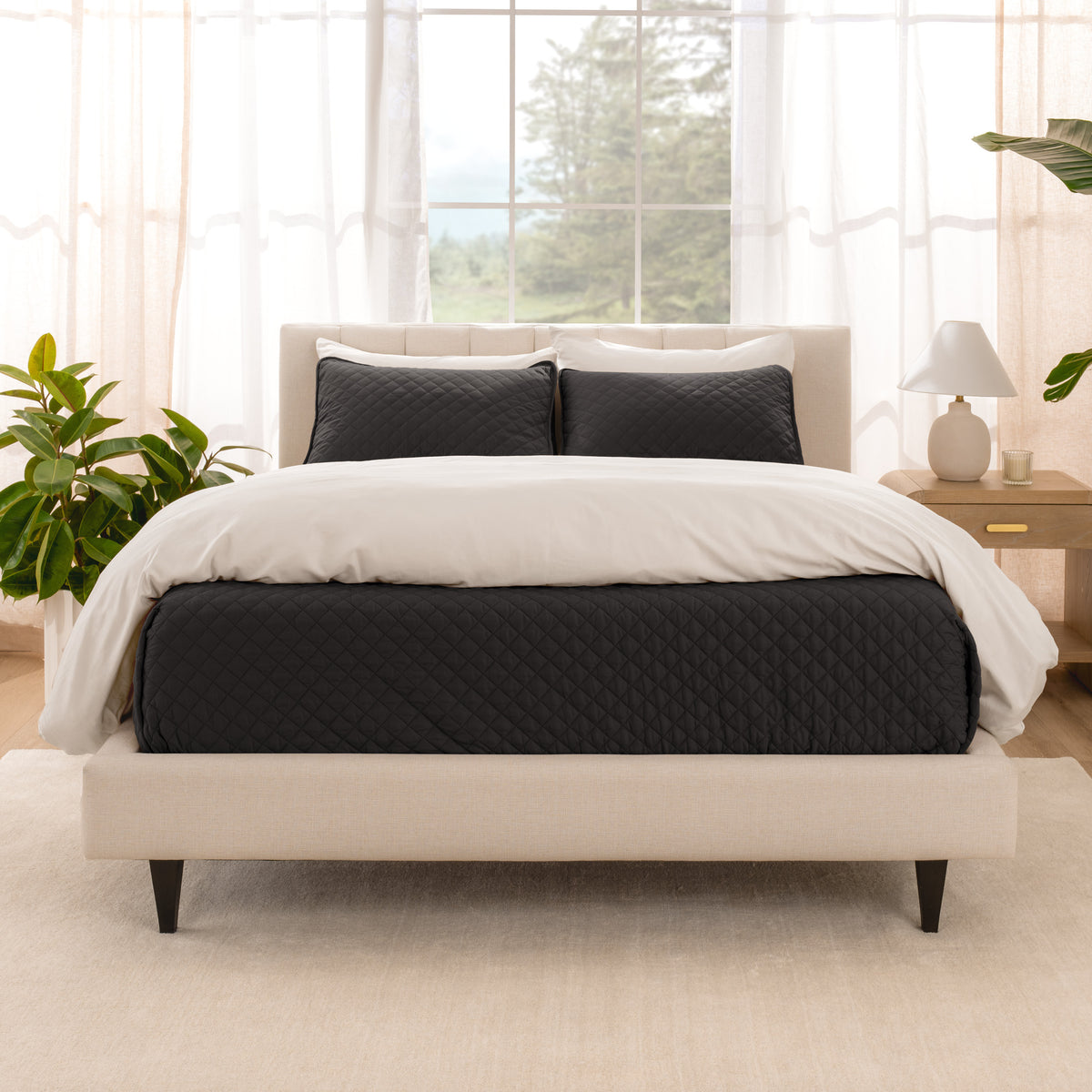 A bright bedroom with a coverlet set on the bed