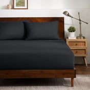 A bed dressed in a fitted sheet and two matching pillowcases.