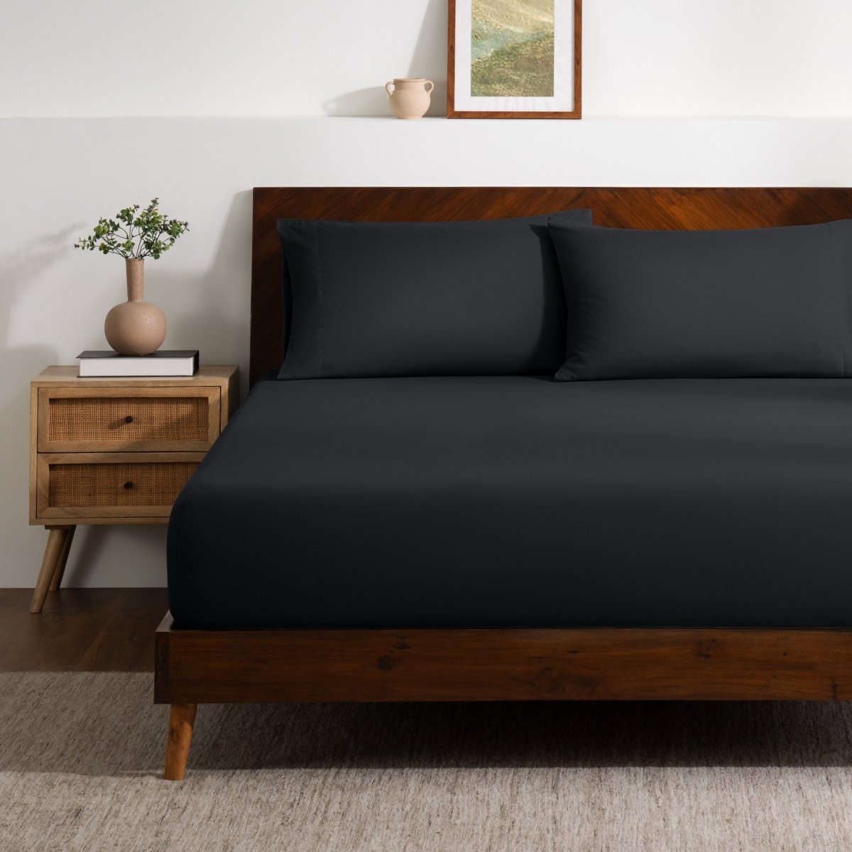 A bed made with a single fitted sheet and two matching pillowcases.