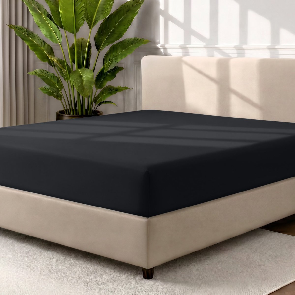 A fitted sheet covering a bed with a cream colored frame, styled in a bedroom setting with a large potted plant.