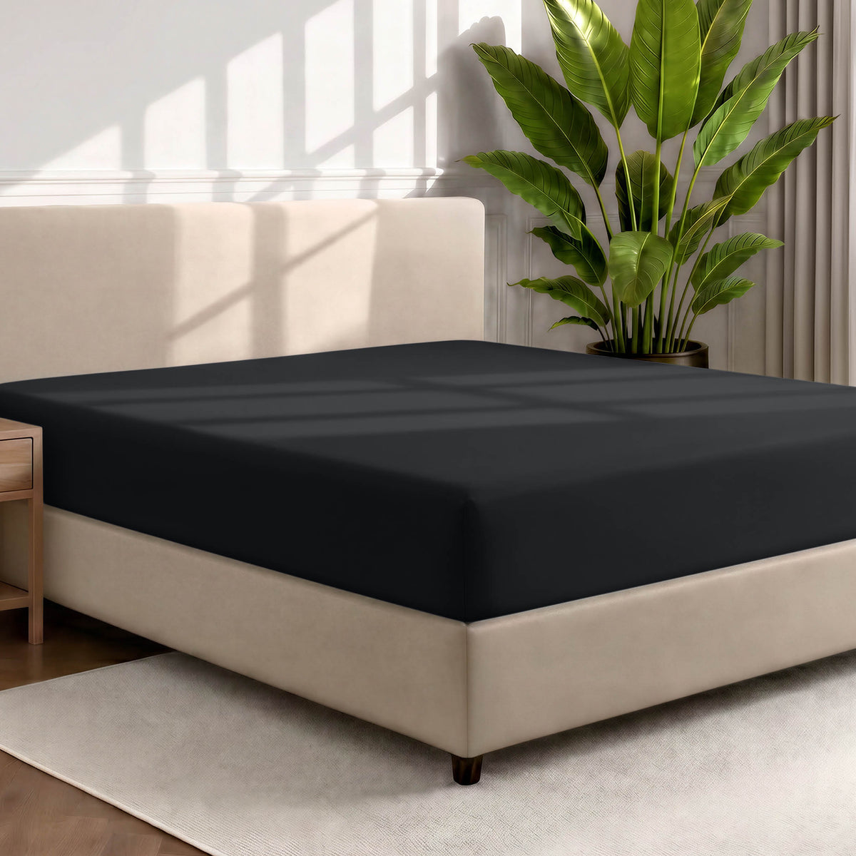 Bed with a fitted sheet in a room with a large plant and rug