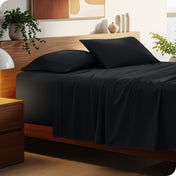 Bed with microfiber bedding and wooden headboard in a bedroom setting