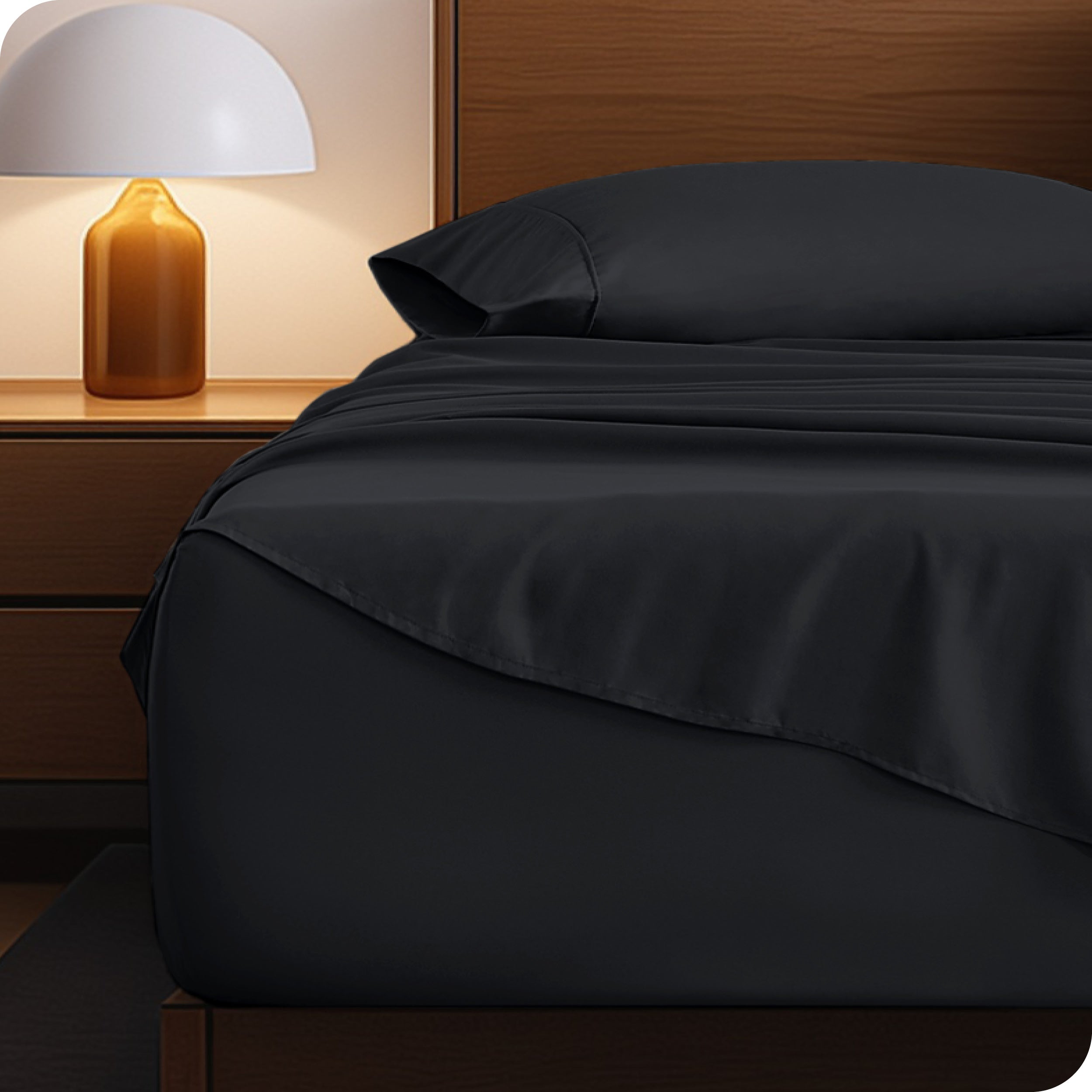 Microfiber bed sheets on a neatly made bed with a wooden headboard and nightstand.