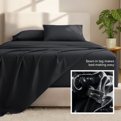 Bed sheets and pillows on a bed with a plant in the background