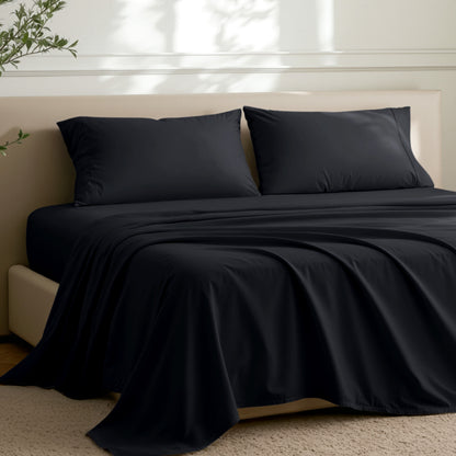 Microfiber sheets on a bed in a well-lit room with a plant.