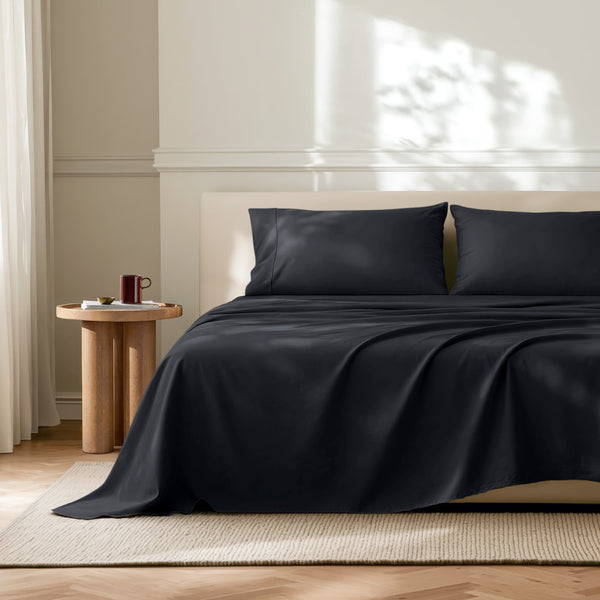 Neatly made bed with microfiber bedding in a bright bedroom.