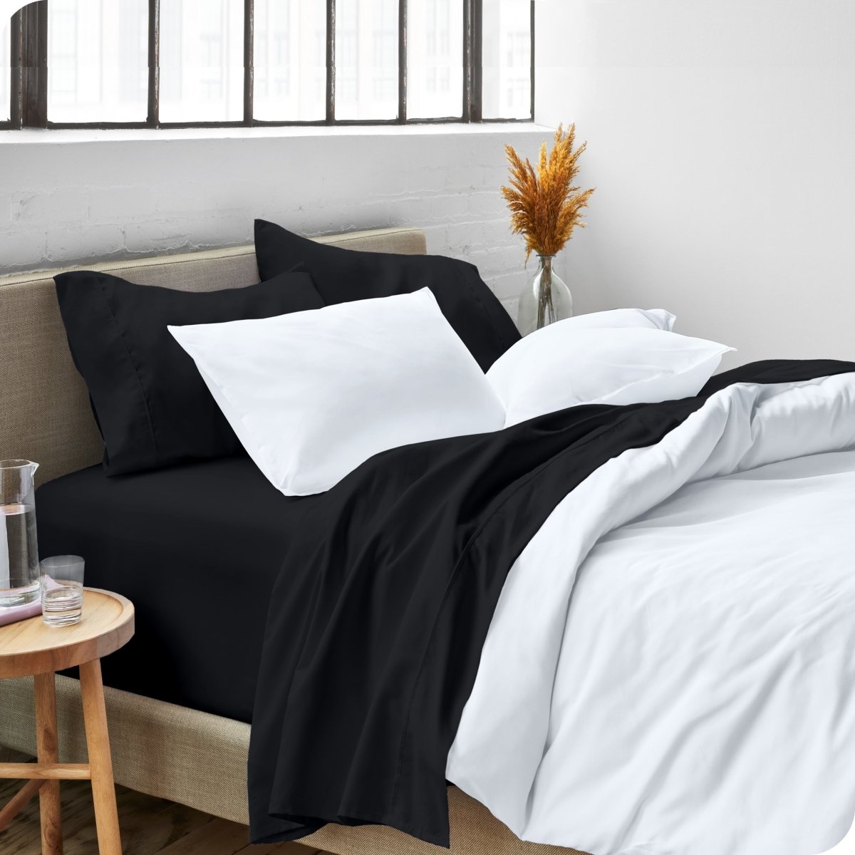 A side view of a bed made with microfiber sheets and a white duvet cover