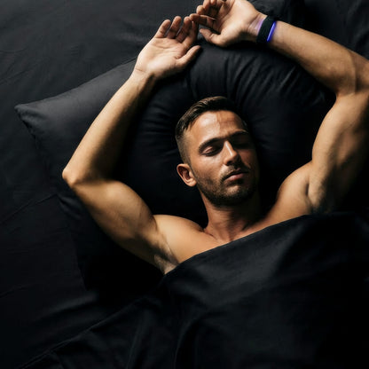 Man lying on a bed with his arms above his head.