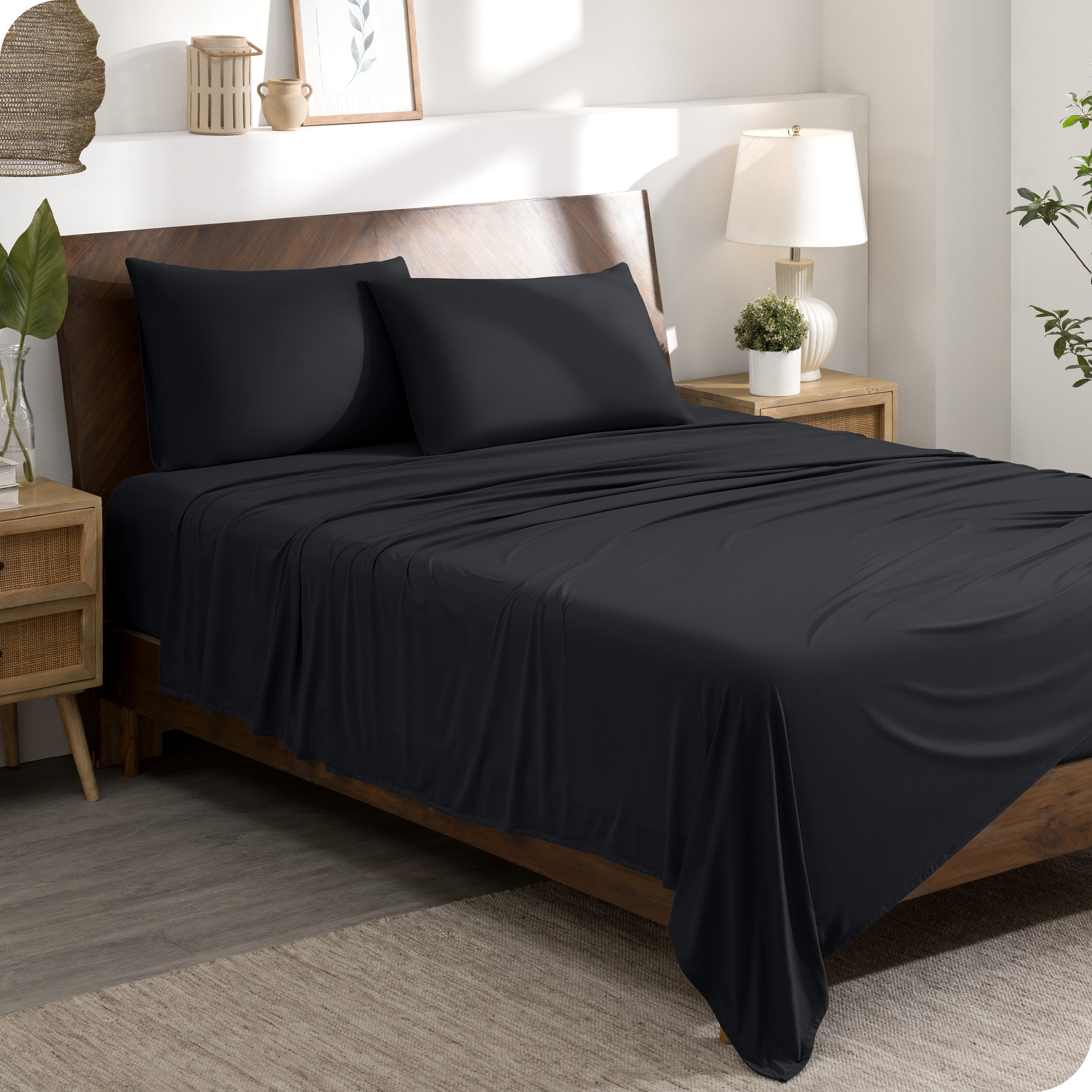 A modern bedroom set with a black sheet set on the bed