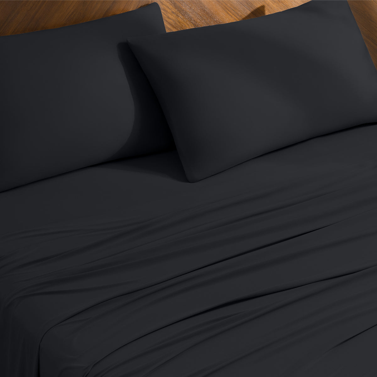 Bed sheets and pillowcases on a bed with a wooden headboard