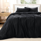 Bed with washed bedding and white pillows in a bright room