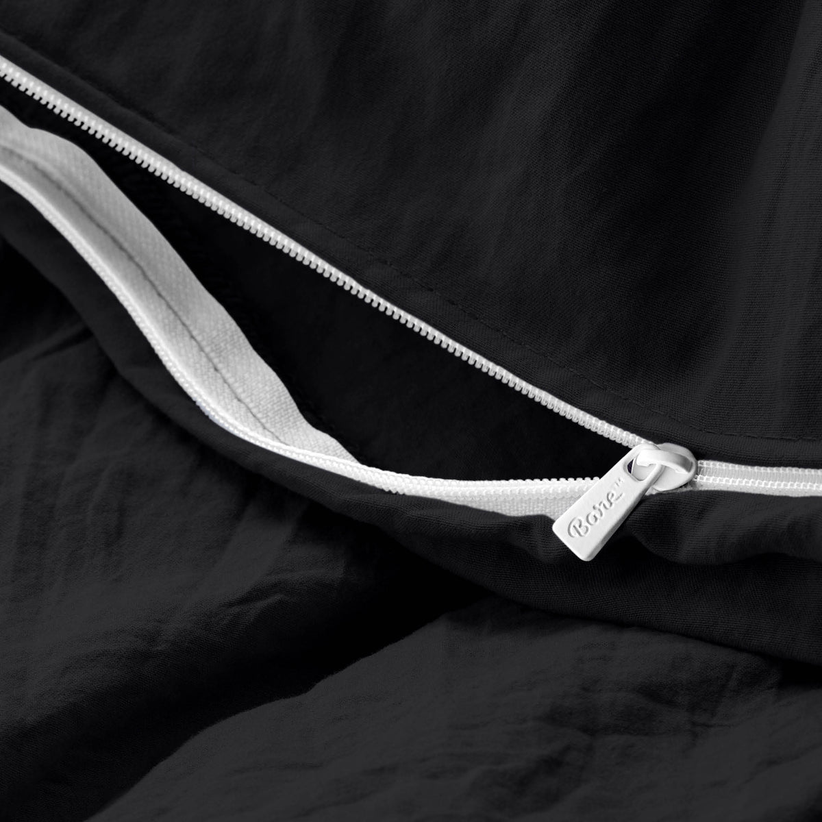 Close-up of a duvet cover with a zipper, featuring the brand Bare Home