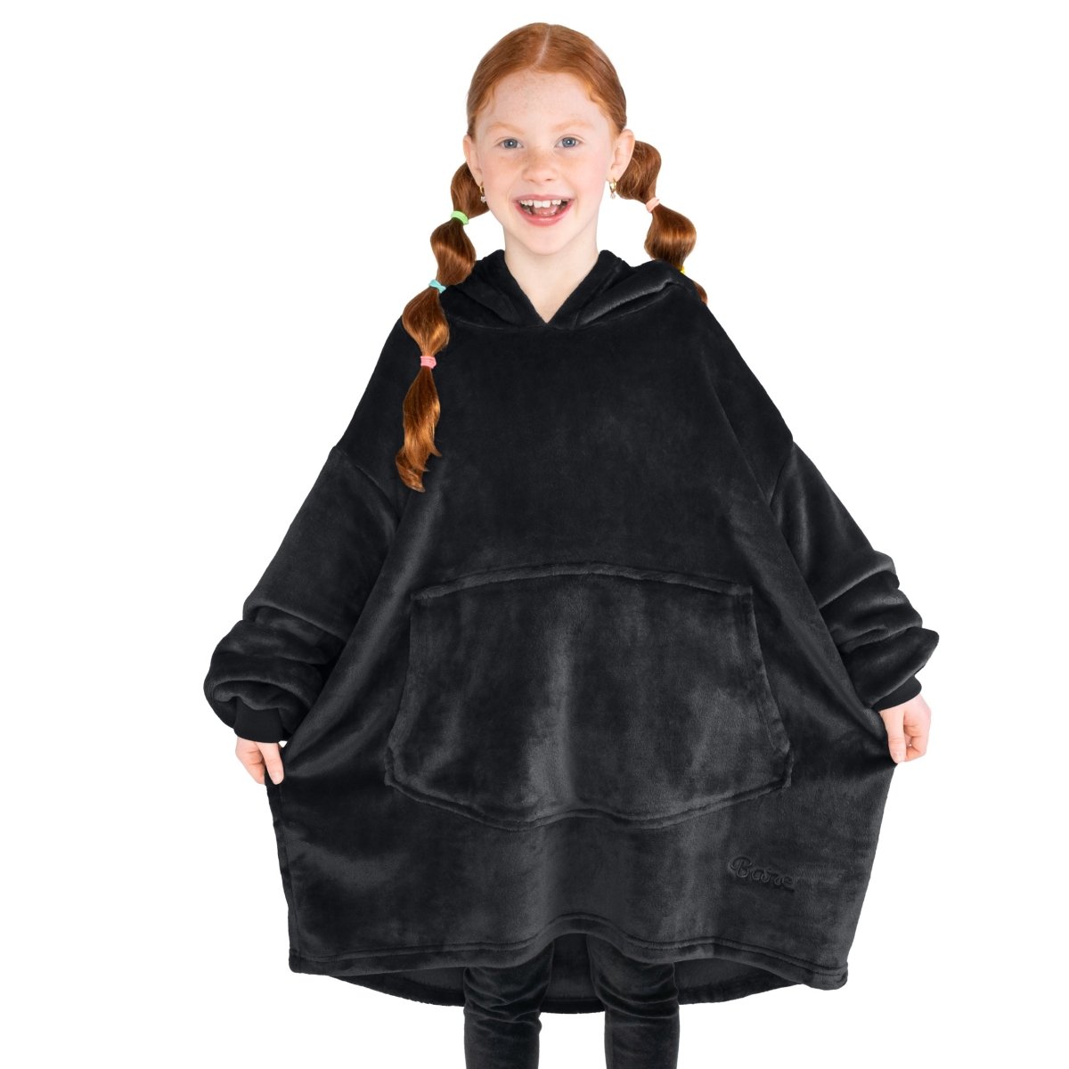 A girl has a microplush wearable blanket on