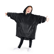 A child has a hooded microplush wearable blanket on and her arms are stretched out