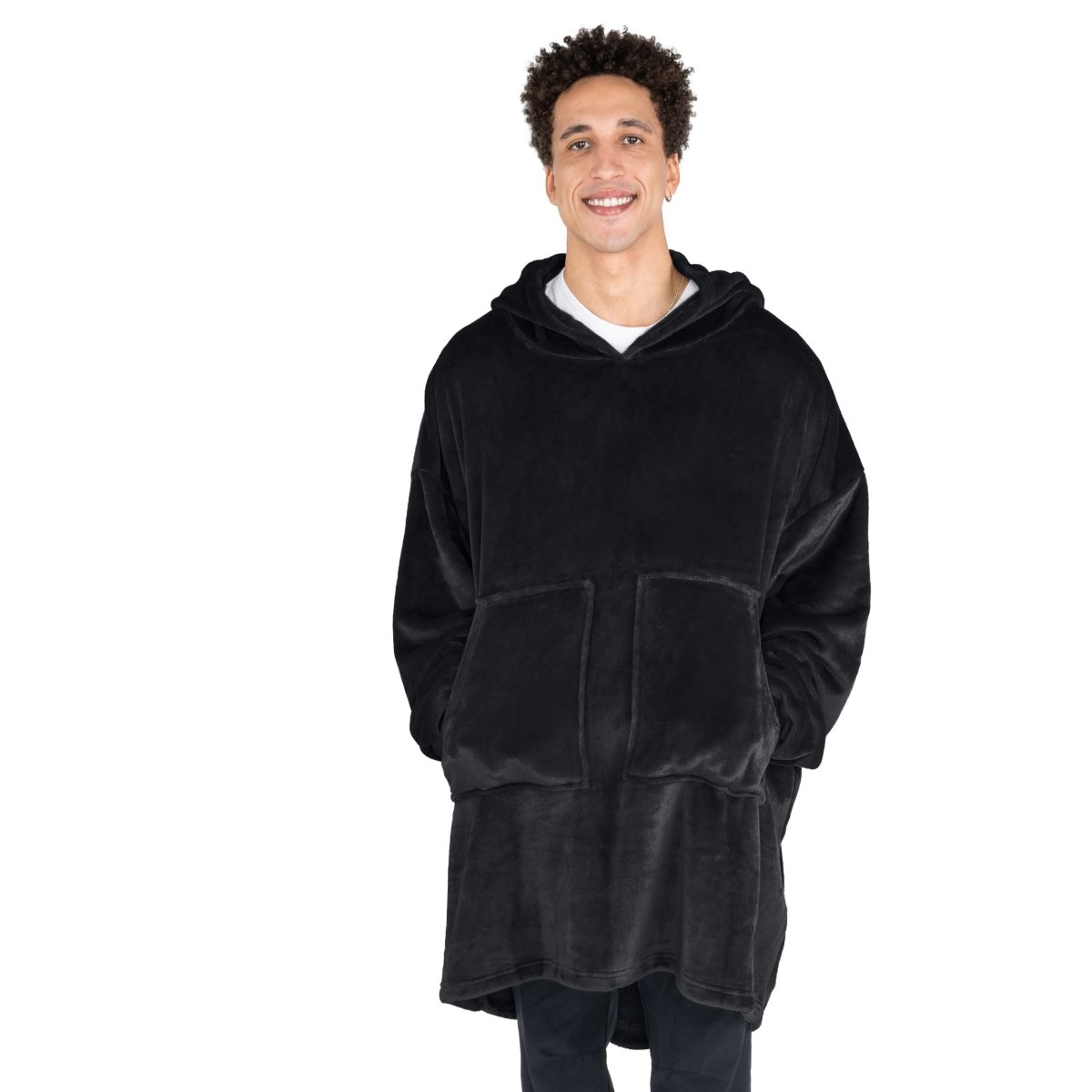 A man with his hands in the pockets of the wearable blanket he has on