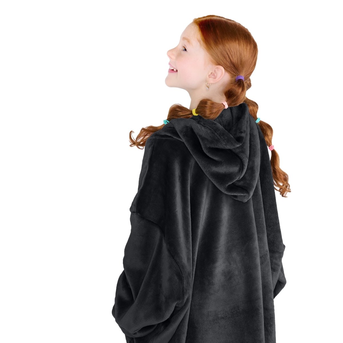 A girl has a microplush wearable blanket on