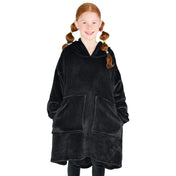 A girl is standing while wearing a microplush wearable blanket with her hands in the pockets