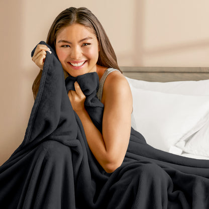 A woman cuddling with a microplush blanket