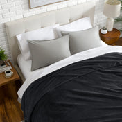 Neatly made bed with a chevron blanket over the comforter
