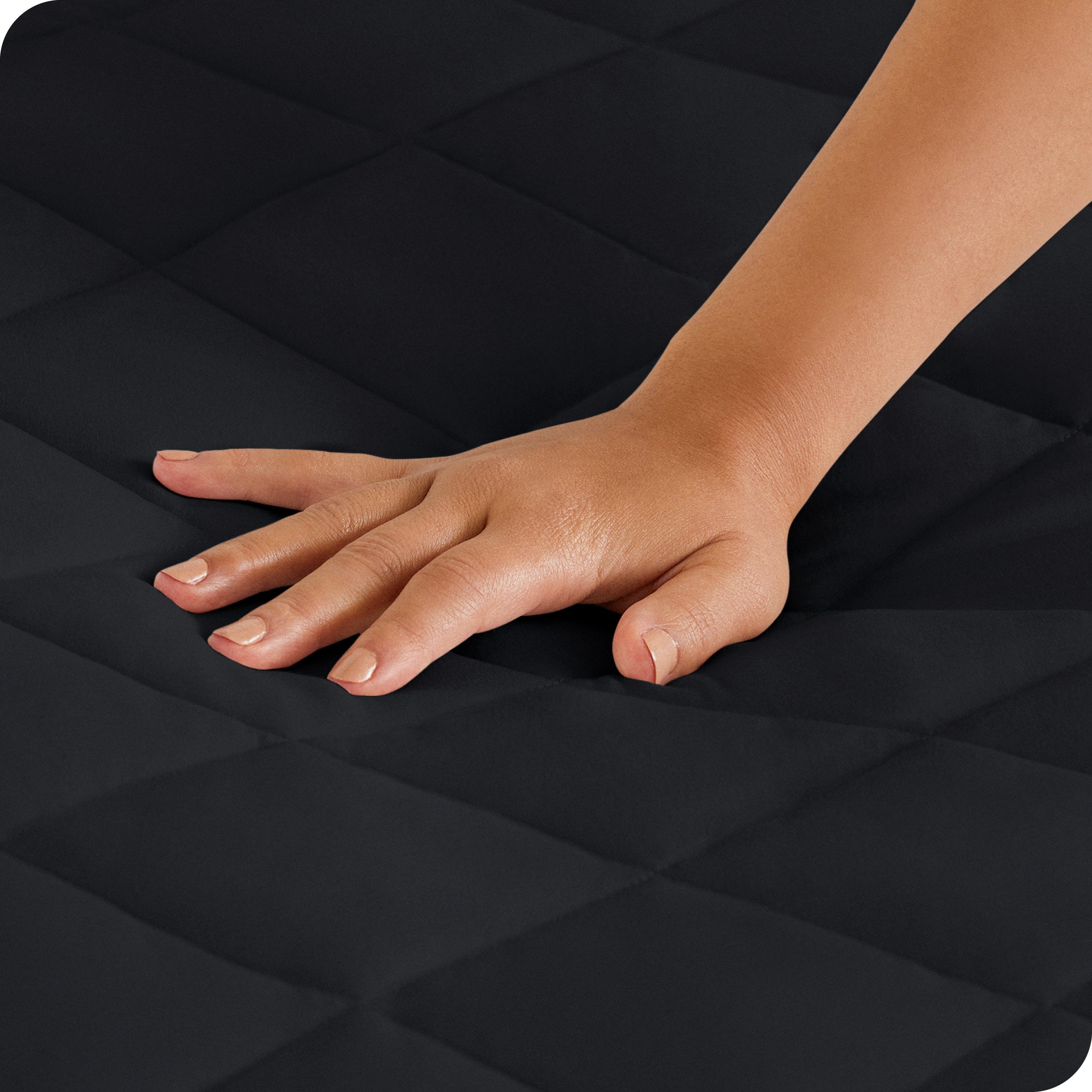 Close up of a woman's hand pressing down on a mattress pad